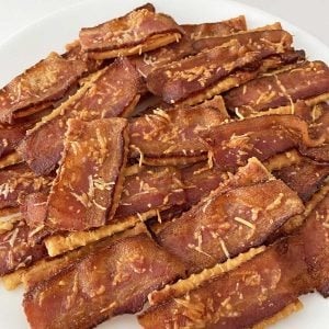 Parmesan Bacon Crackers piled on a white plate.
