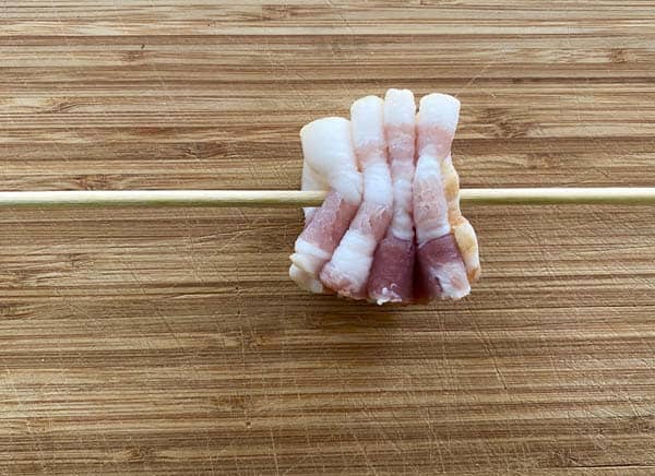 A strip of folded bacon on a skewer.