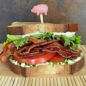 bacon lettuce avocado tomato sandwich skewered with pig toothpick