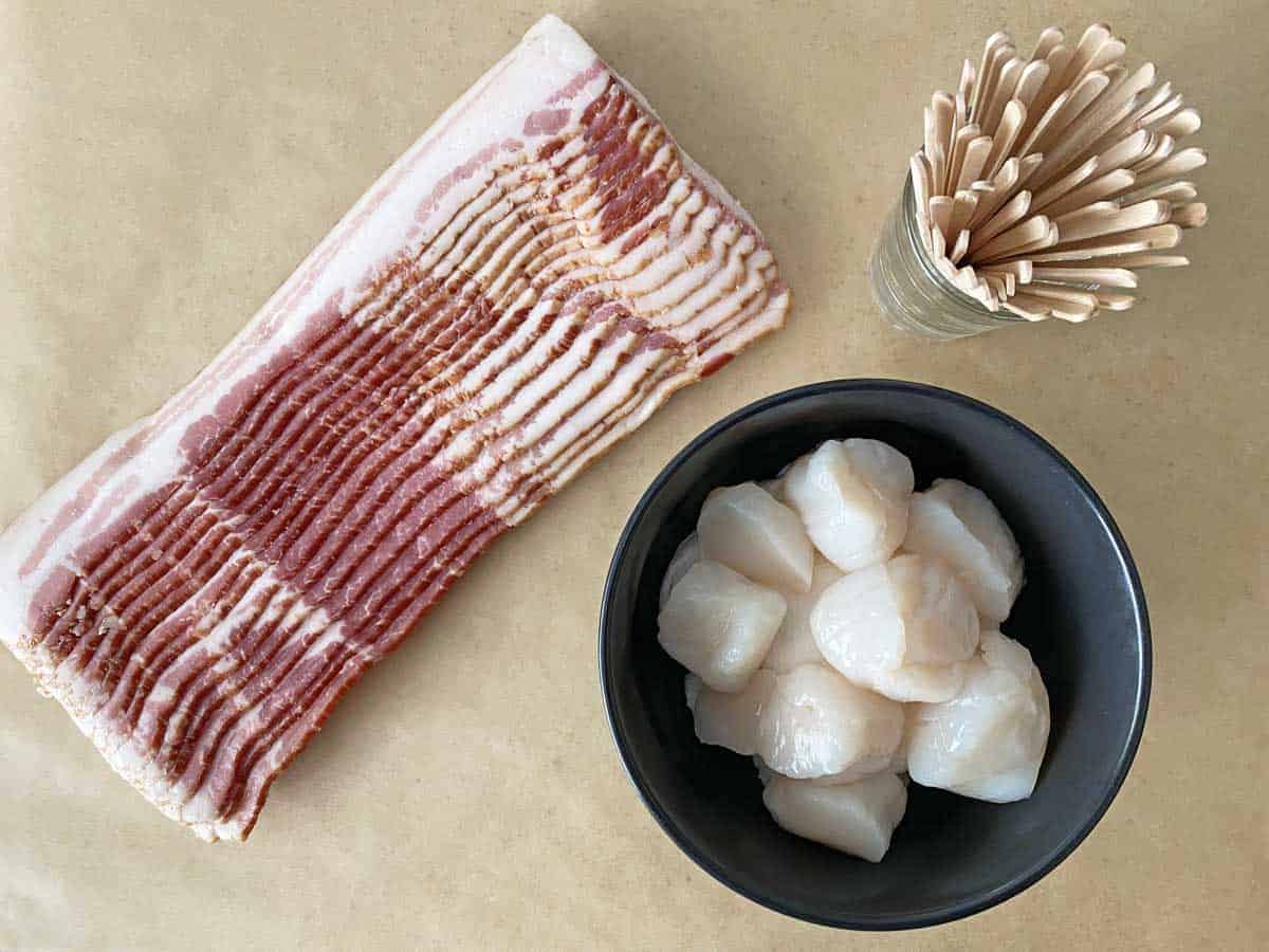 A pound of bacon, 24 sea scallops and a container of wooden cocktail picks.