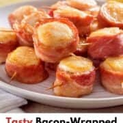 A dozen oven cooked bacon wrapped scallops on a white serving plate.