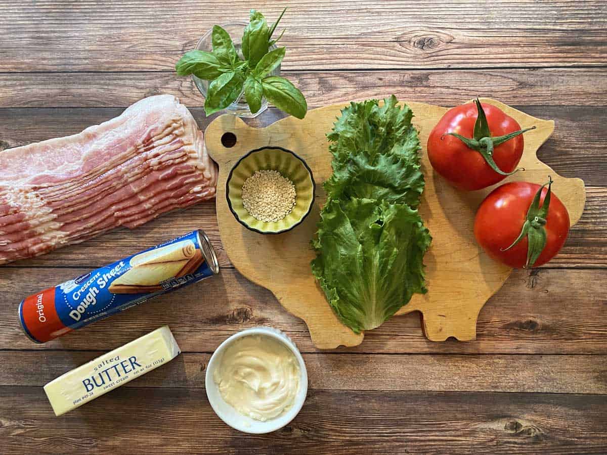 Bacon, fresh basil, sesame seeds, lettuce, two tomatoes, mayonnaise, butter and a tube of crescent dough sheets.