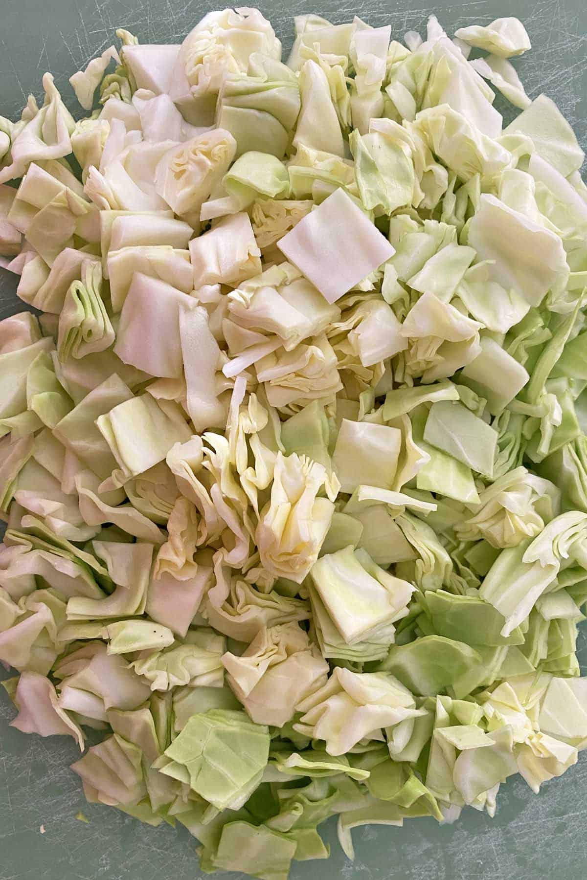 chopped cabbage on a green cutting board.