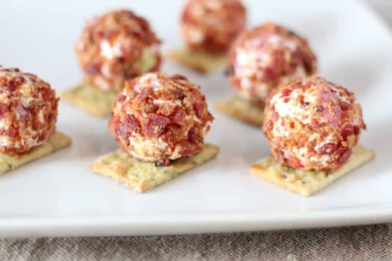 close up of six bacon cheeseball bites on a white platter