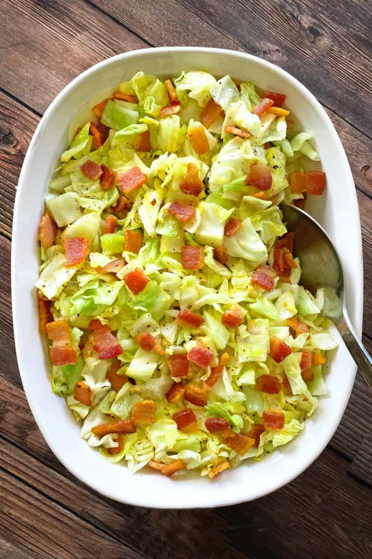 White oval dish filled with bacon fried cabbage