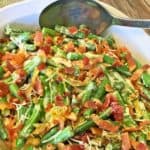 close up of bacon green bean casserole with serving spooon