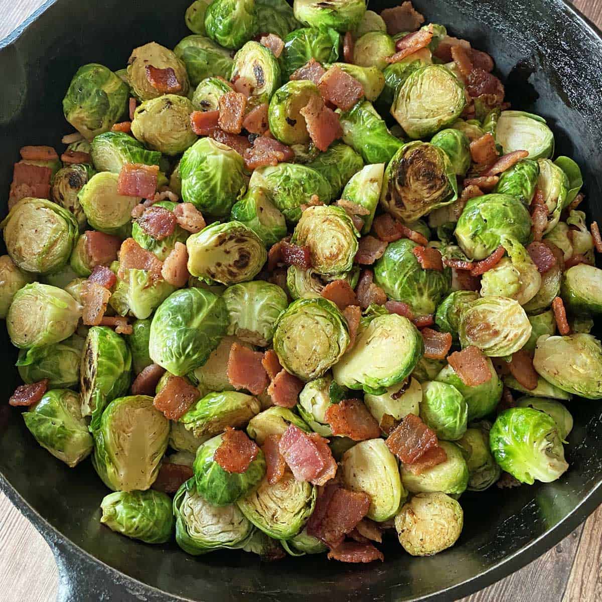 Cast iron skillet with finished Brussel sprouts with bacon, garlic and Balsamic, ready to serve.