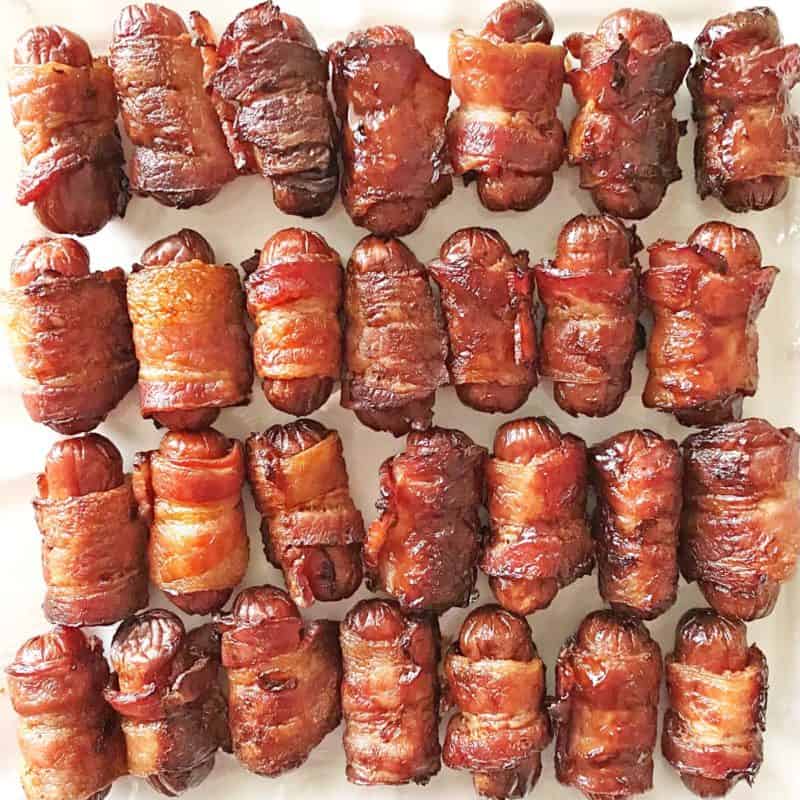 close up of 28 pieces of bacon wrapped little smokies sausages appetizers.