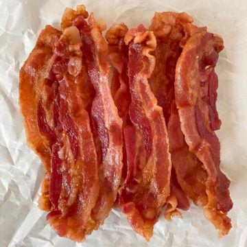 A pile of microwaved bacon on a crumpled sheet of parchment paper