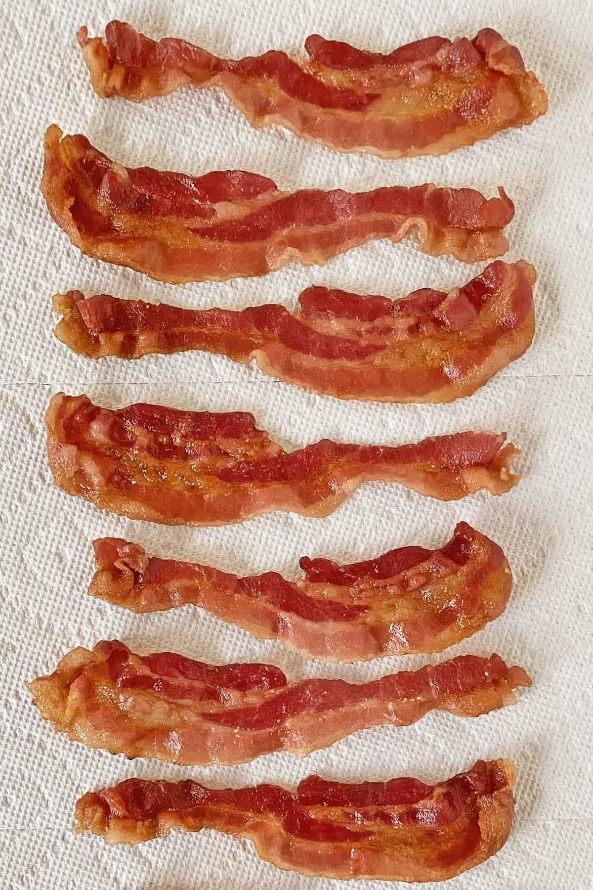 7 strips of cooked bacon draining on a paper towel