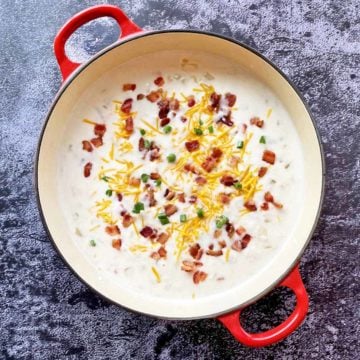 A red pot filled with cream of bacon soup