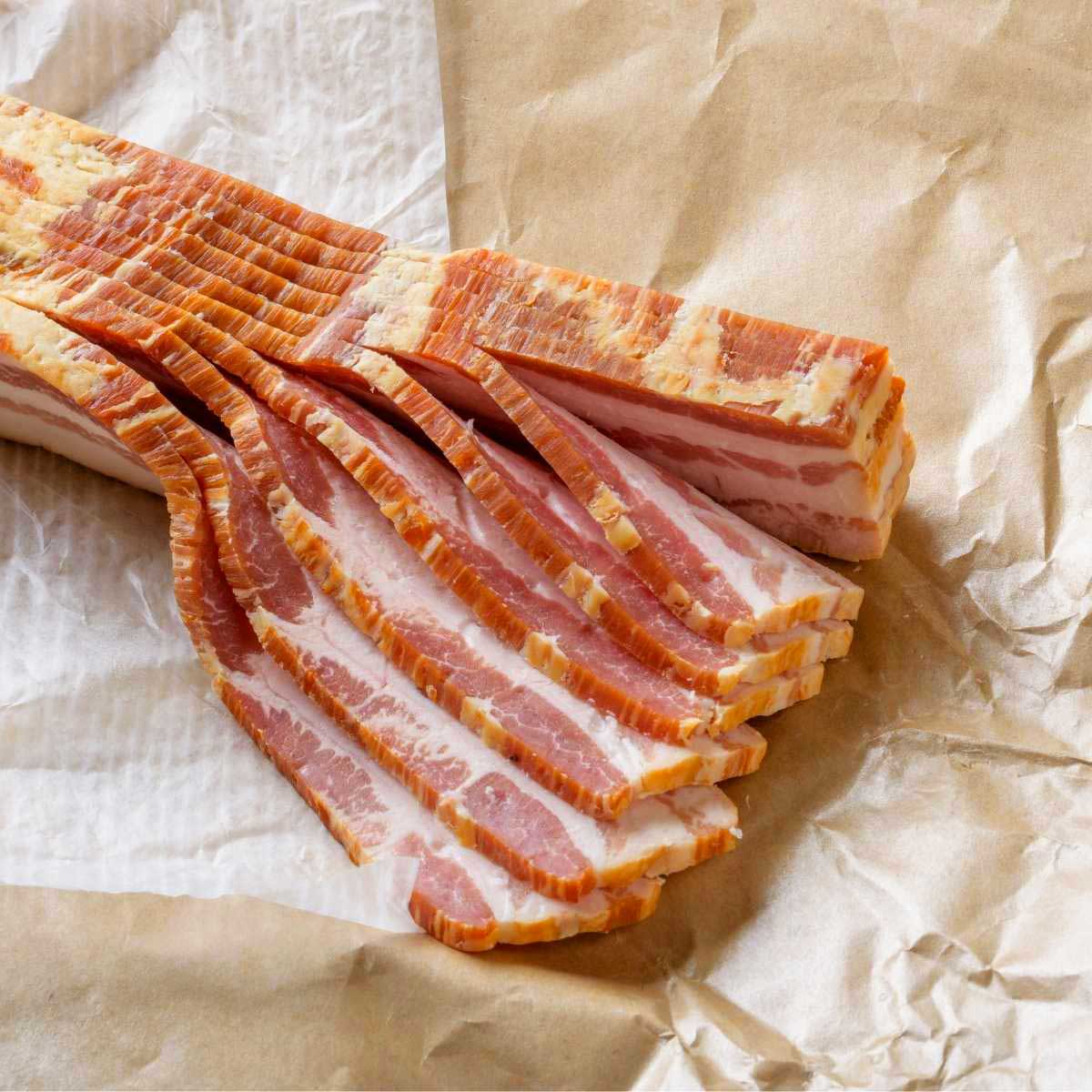 10 slices of raw bacon on a piece of butcher paper