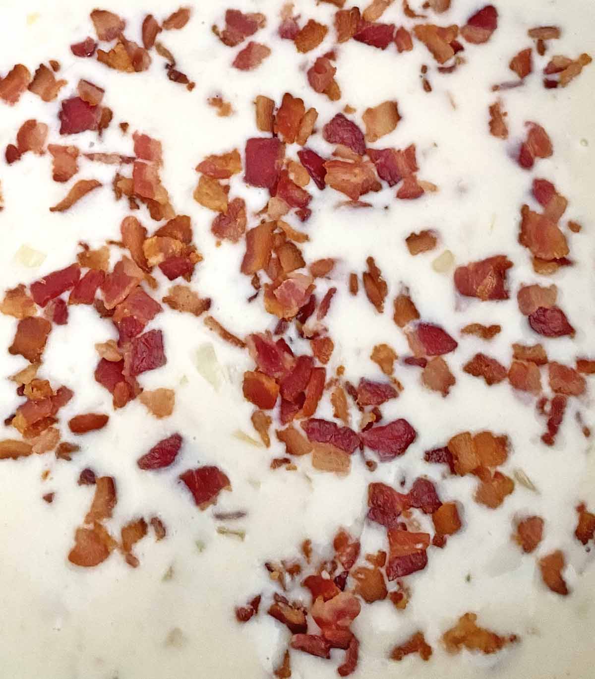 Adding cooked chopped bacon to the cream soup mixture.