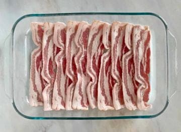 10 strips of uncooked bacon in a glass baking dish.