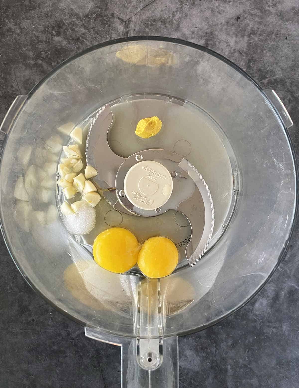 Combining ingredients inside the bowl of a food processor.