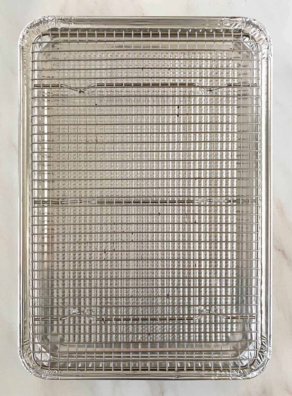 A disposable aluminum foil pan fitted with an oven proof baking rack.