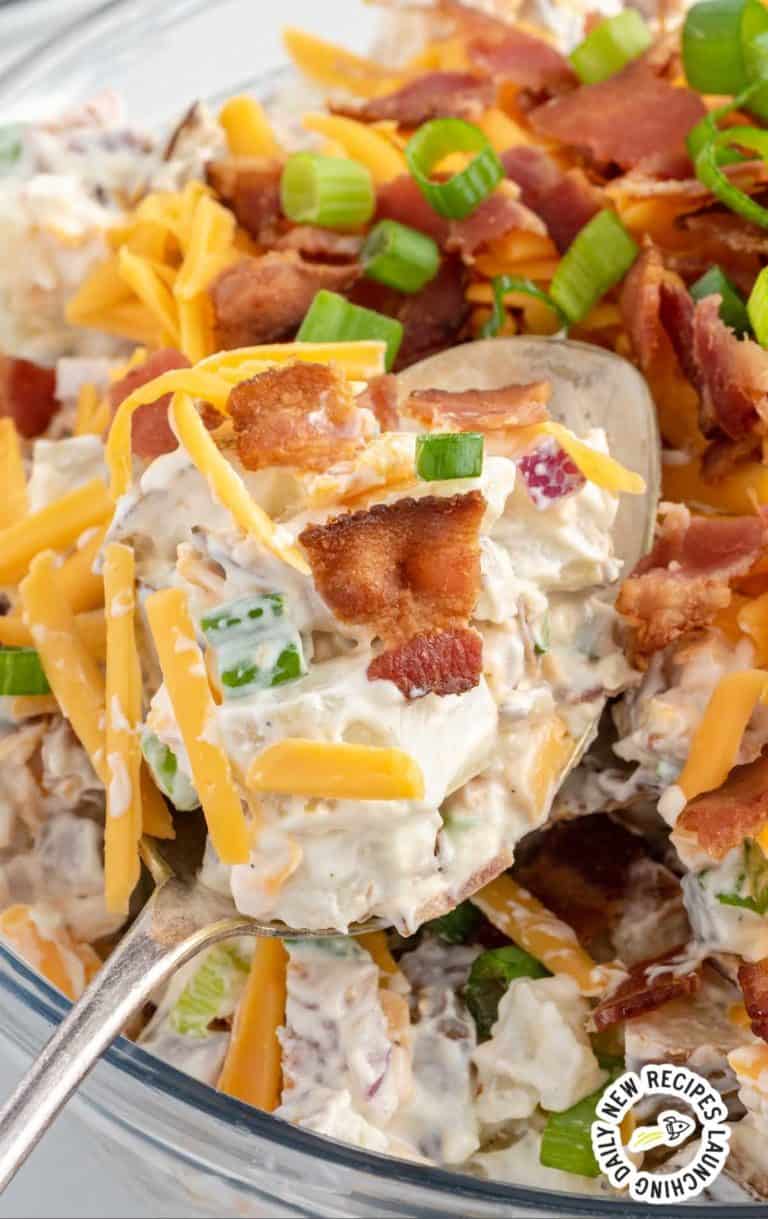 Close up of Loaded Potato Salad topped with shredded cheese and crunchy bacon.