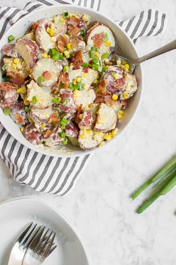 Red Skin Potato Salad with Roasted Corn, Bacon and Green Onions in a serving bowl.