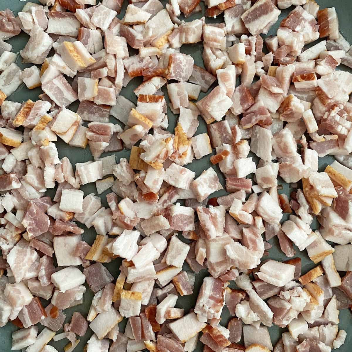 chopped raw thick-cut bacon in a skillet.