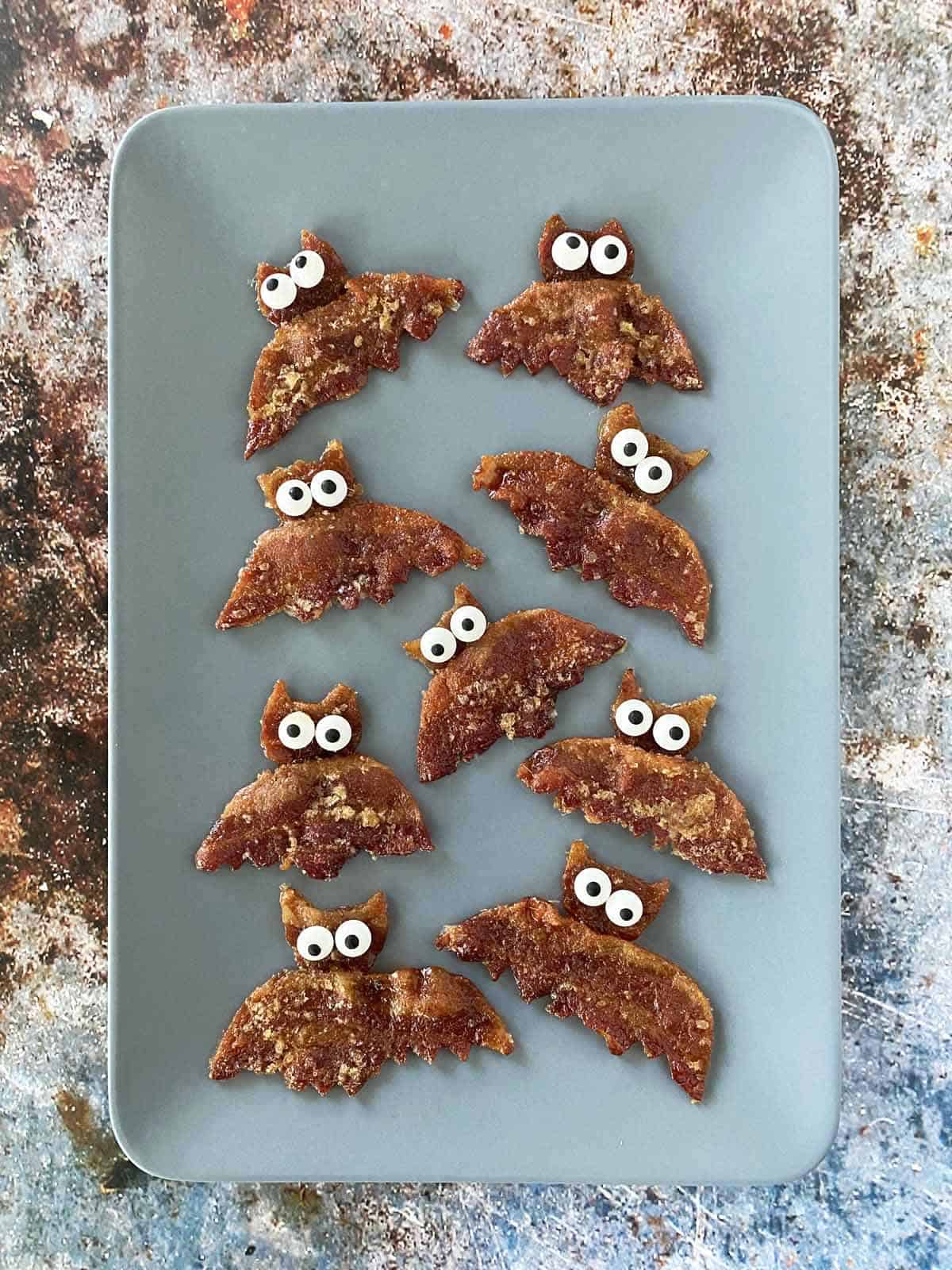 10 pieces of Halloween bacon bats on a gray serving platter.