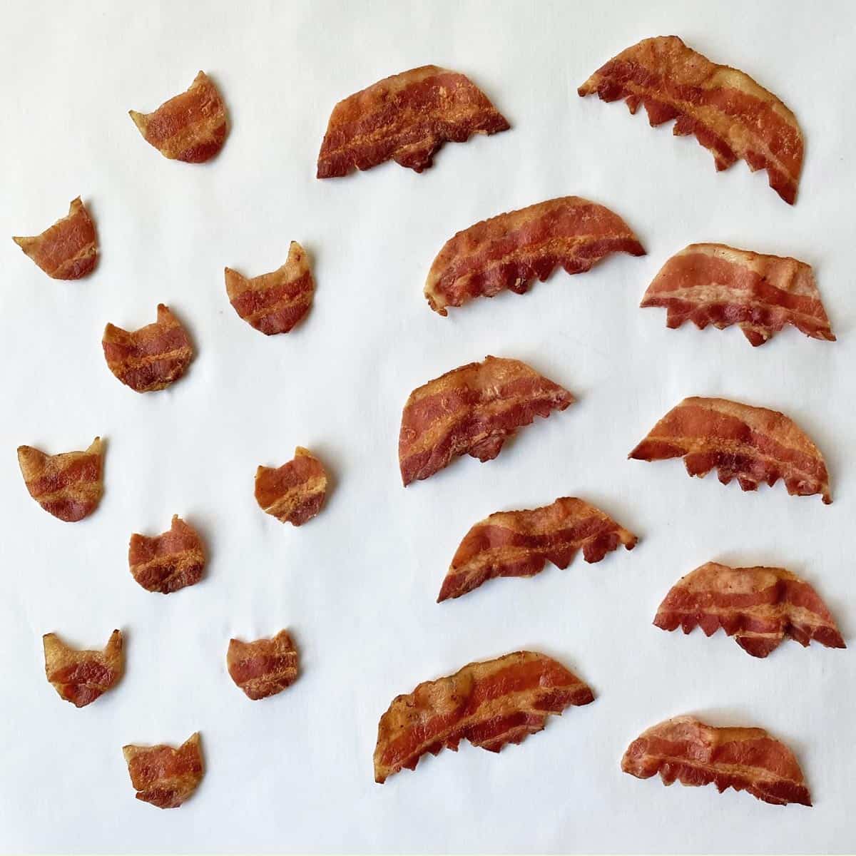 10 bat heads and 10 bat wings cut from pieces of cooked bacon.
