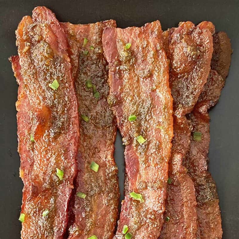 Close up of jalapeno bacon on a black plate.