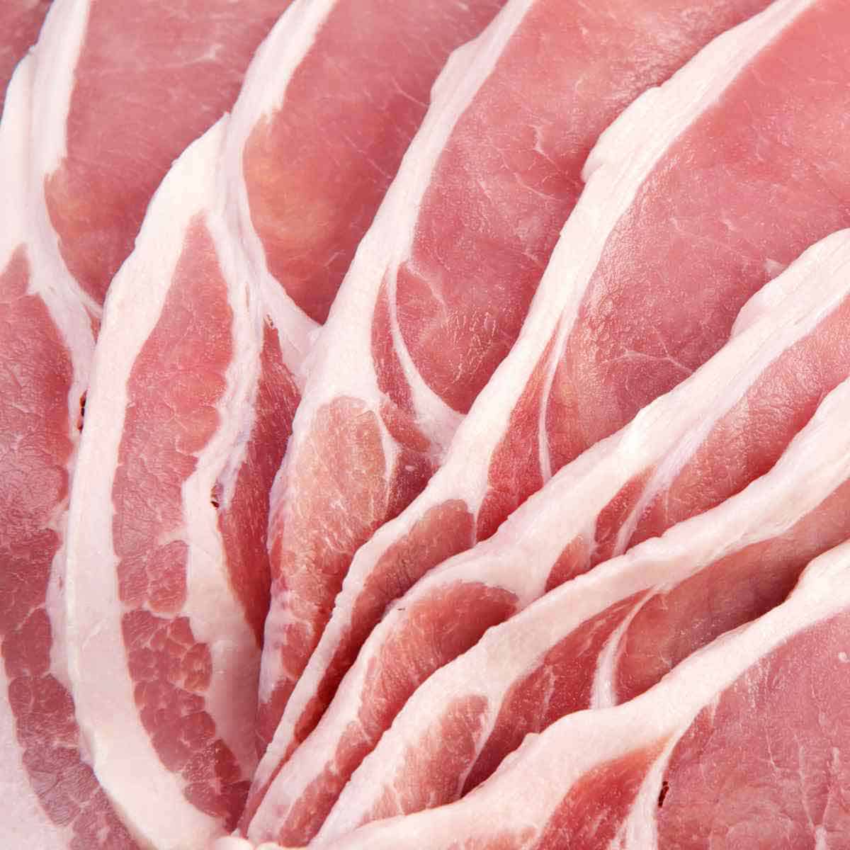 Seven slices of uncooked back bacon.