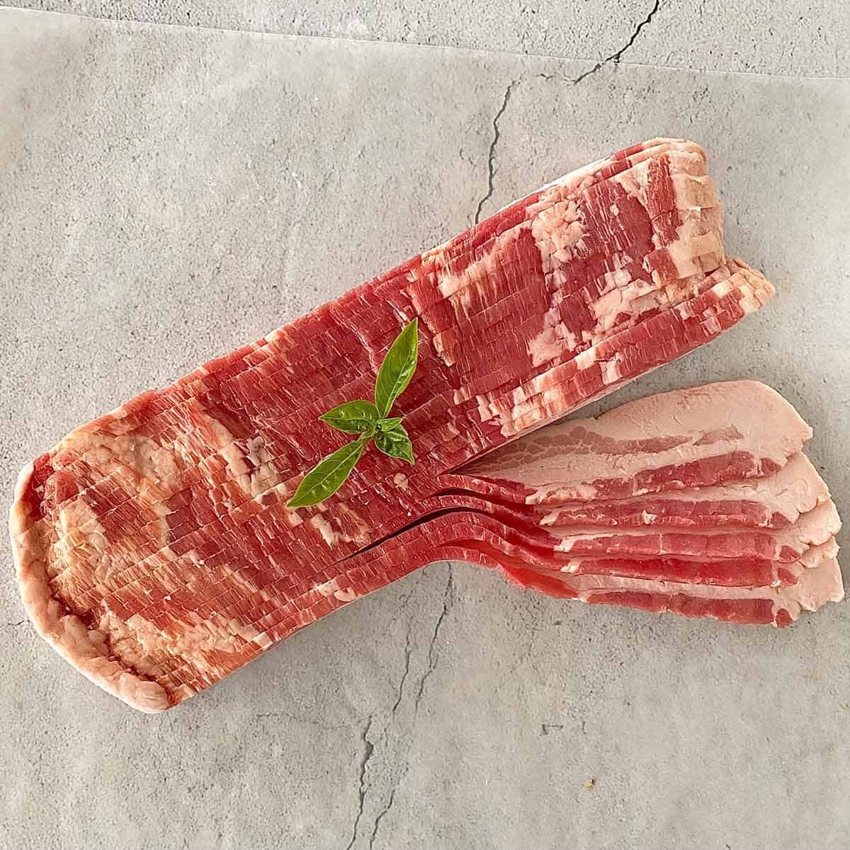 Thick sliced raw bacon on a counter.
