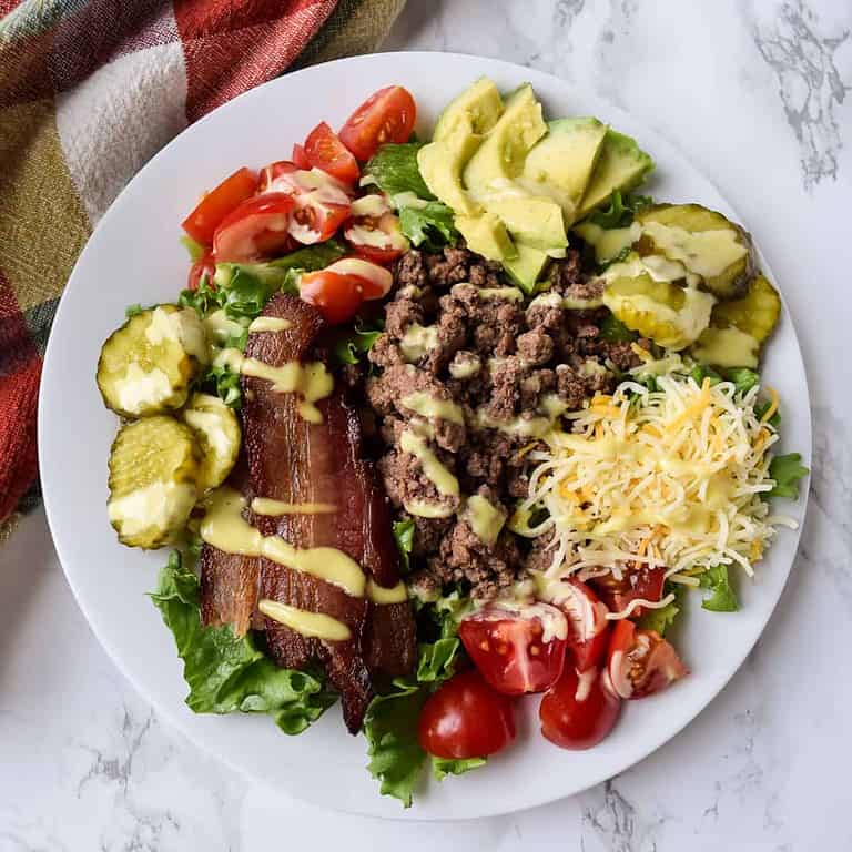 Bacon cheeseburger salad drizzled with dressing.