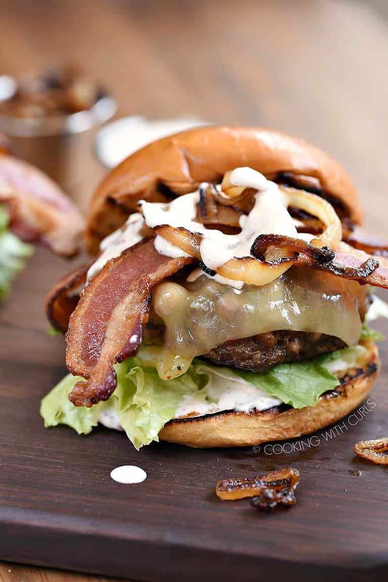 A grilled bacon cheeseburger with caramelized onions.