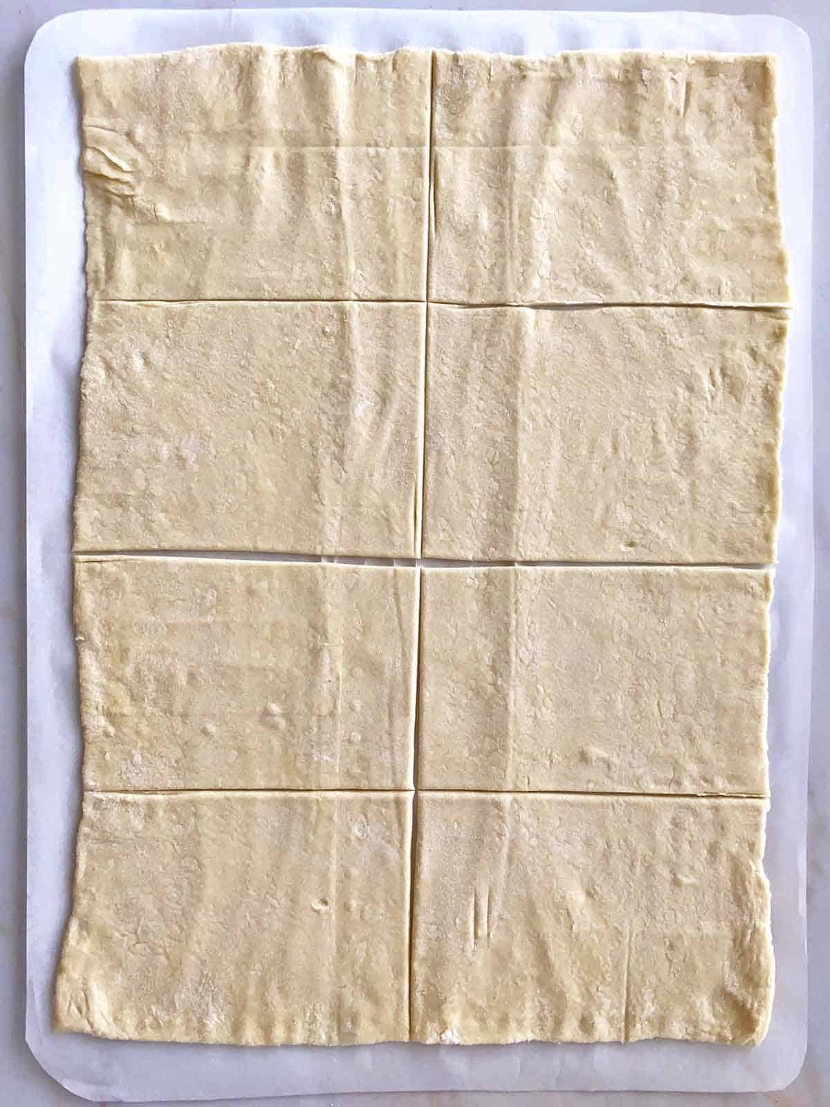 A sheet of puff pastry rolled out and cut in 8 rectangles.