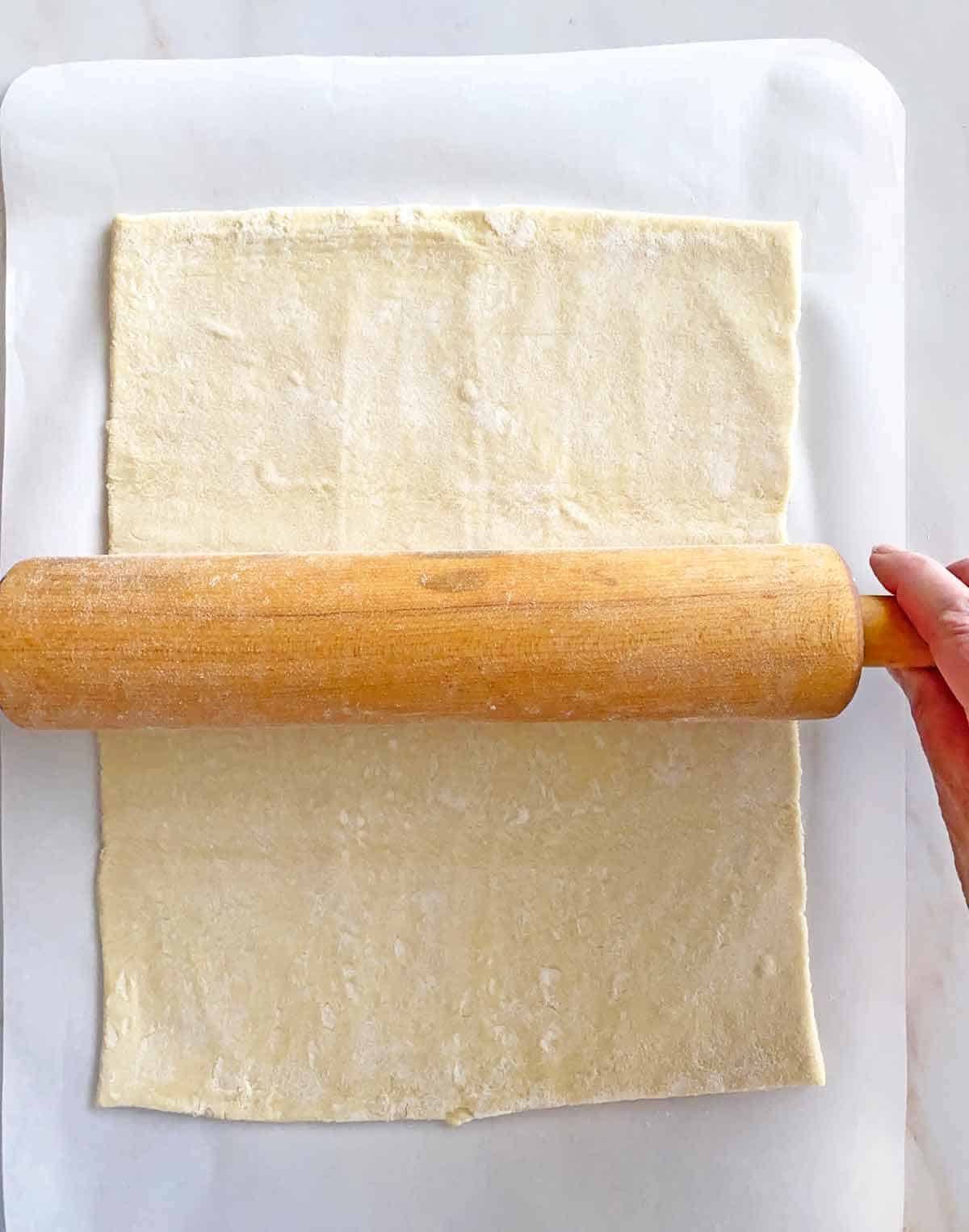Using a rolling pin to roll out puff pastry.