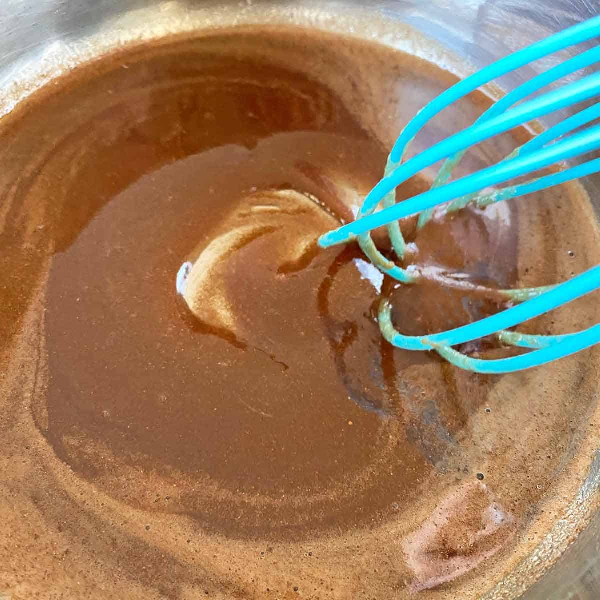Combining glaze ingredients with a blue whisk.