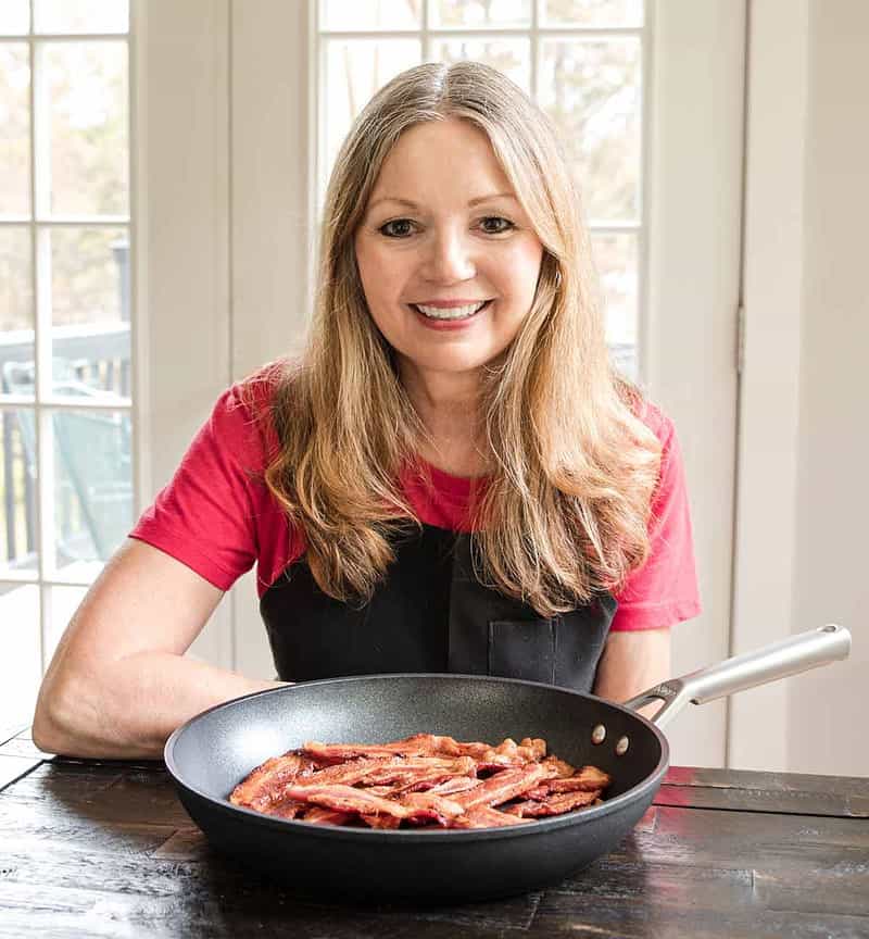 Eliza Cross, author and BENSA Bacon Lovers Society founder, with a skillet of cooked bacon.