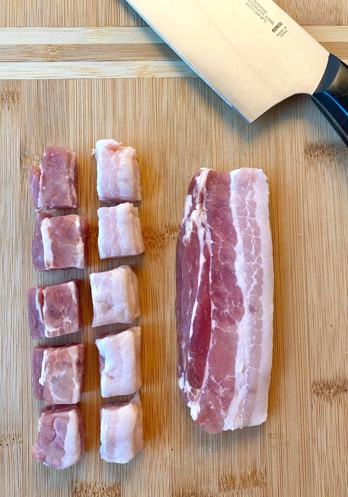 Two halved bacon strip stacks and a knife, showing how to properly cut bacon slices in squares.