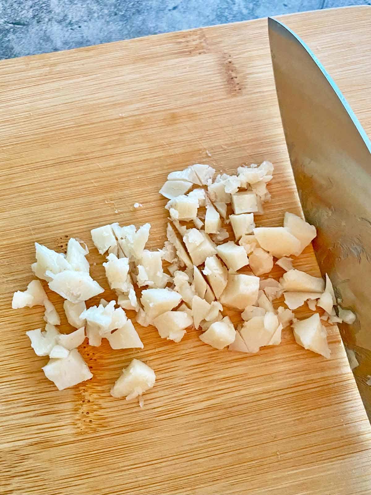 chopping frozen bacon grease on a cutting board.