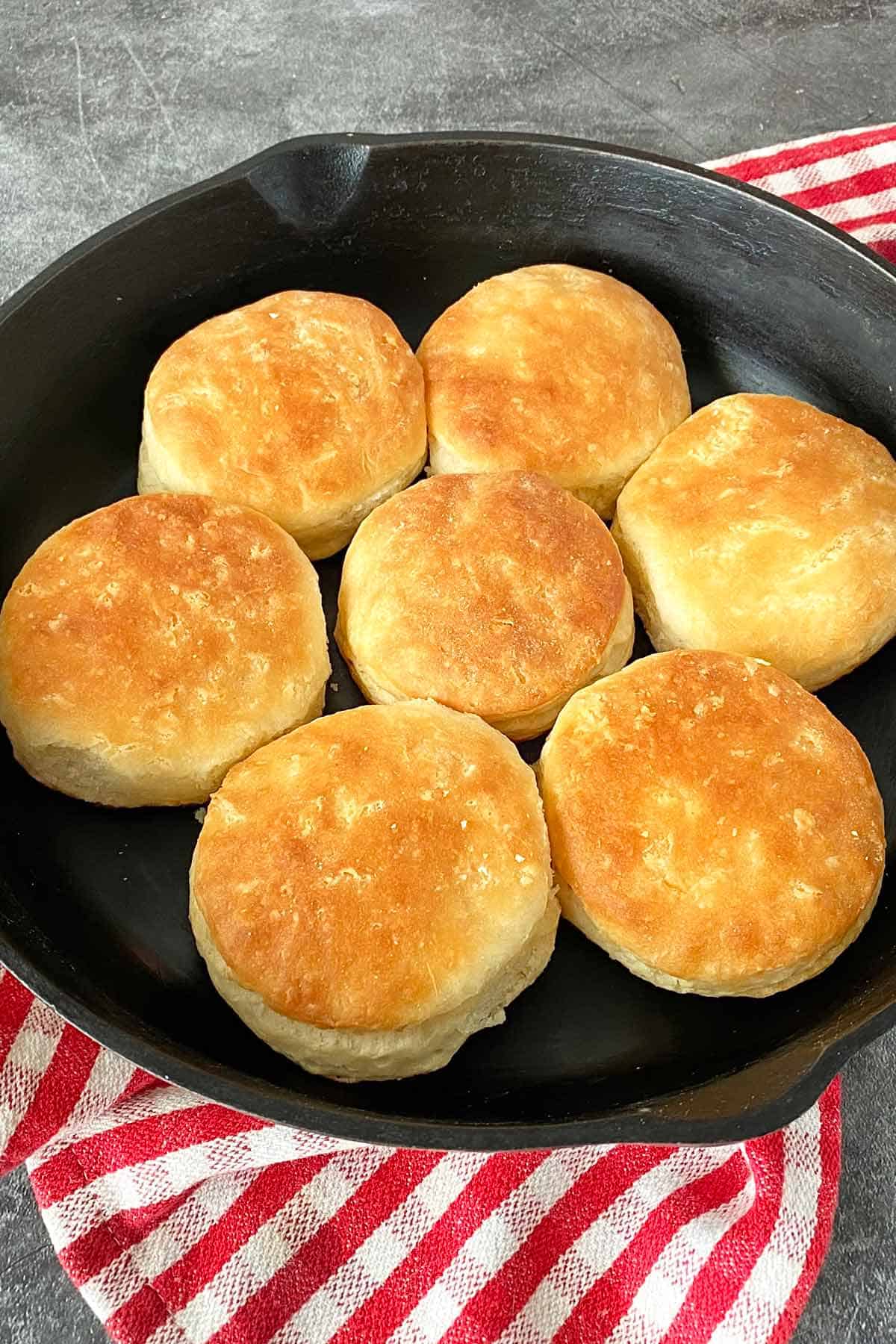 A skillet filled with home baked biscuits made with bacon grease and butter.