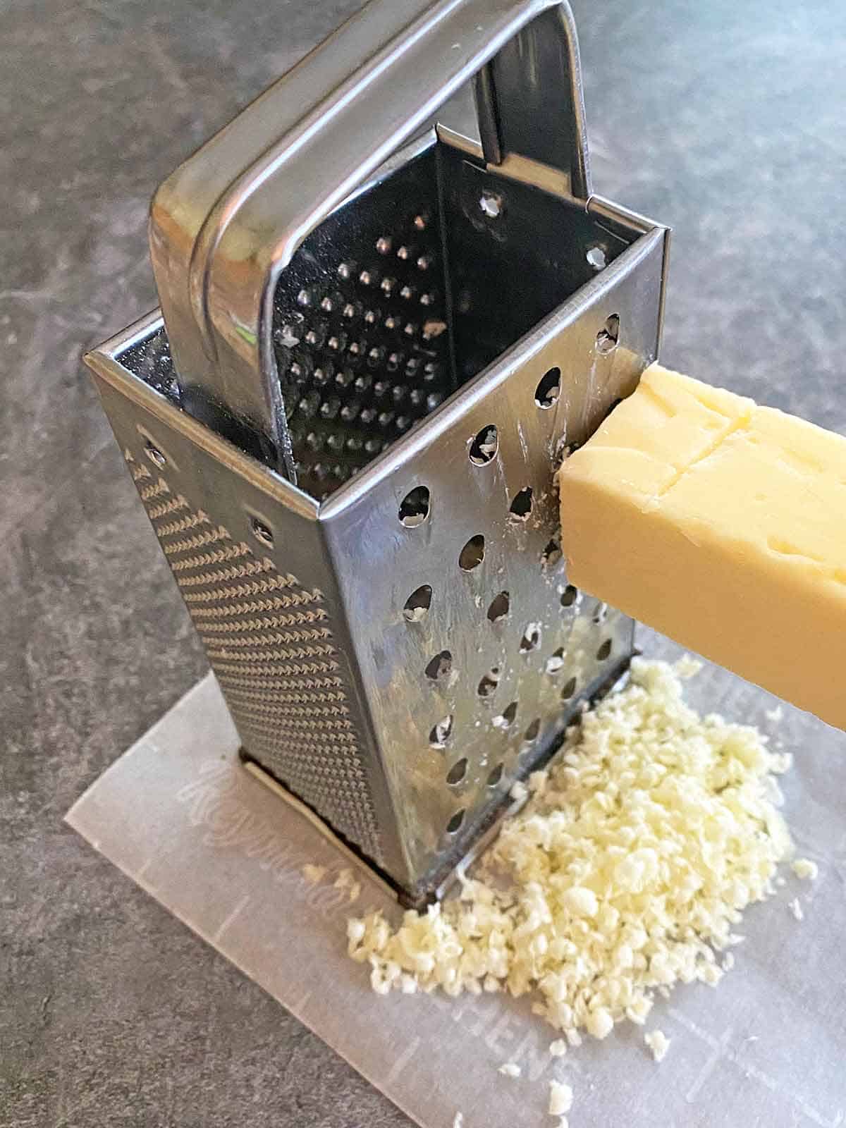 Grating frozen butter on a box grater