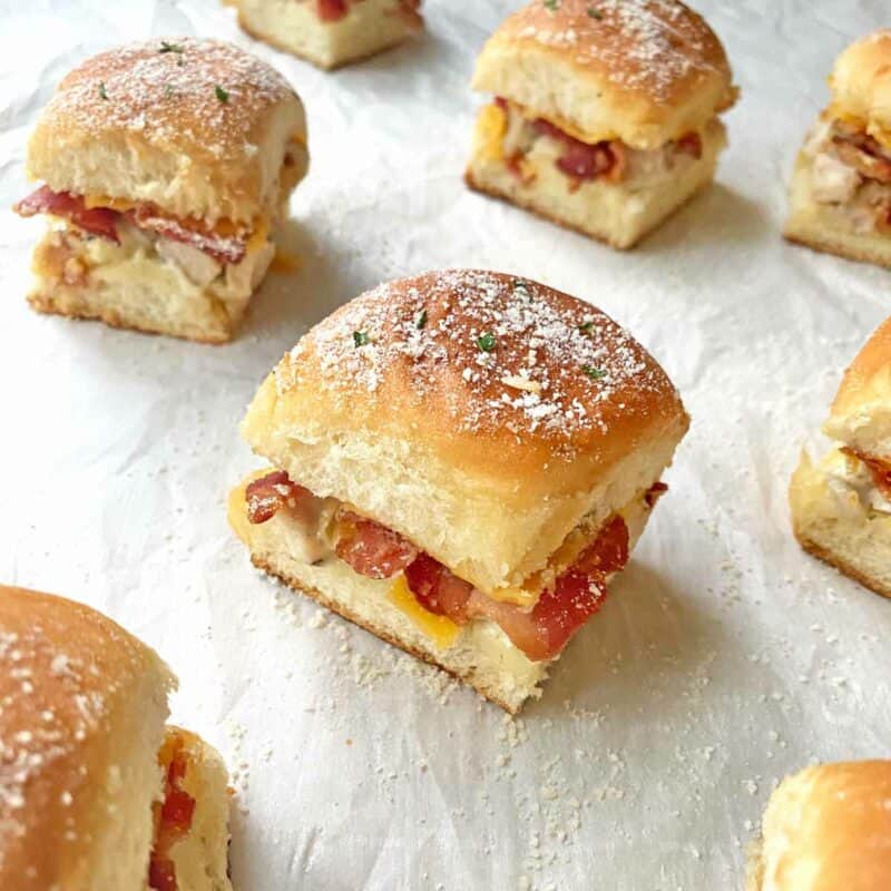 Individual chicken bacon ranch sliders on parchment paper.
