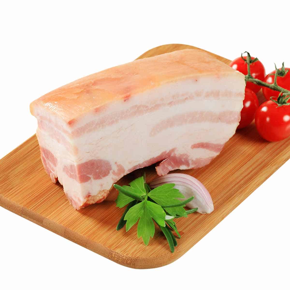A slab of pork belly on a cutting board.