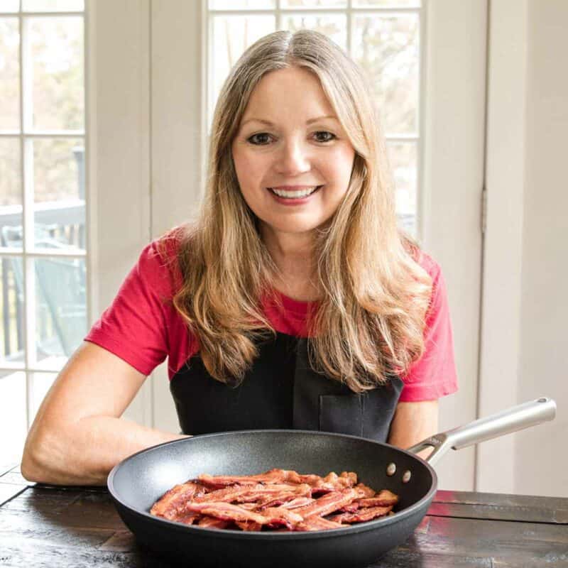 Eliza Cross, founder of BENSA Bacon Lovers Society, with a pan of bacon.