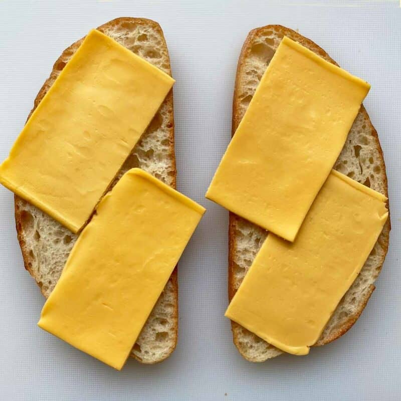 American cheese slices arranged on 2 slices of sourdough bread.