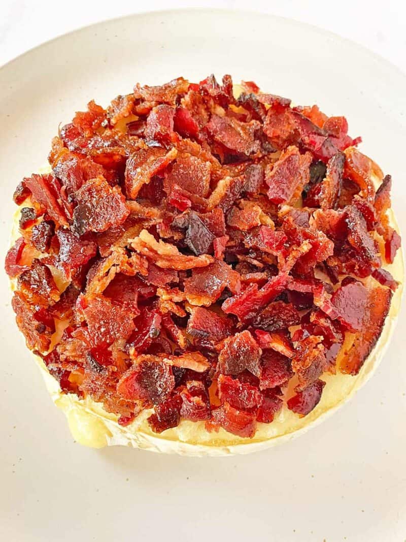 Bacon topping spooned on a warm wheel of Brie cheese.
