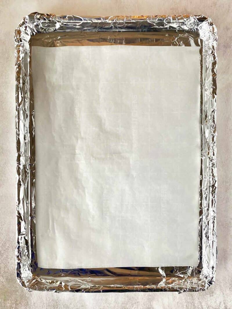 A piece of parchment paper on a foil lined baking pan.