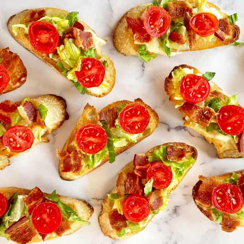 Eight pieces of BLT crostini appetizers ready for serving.
