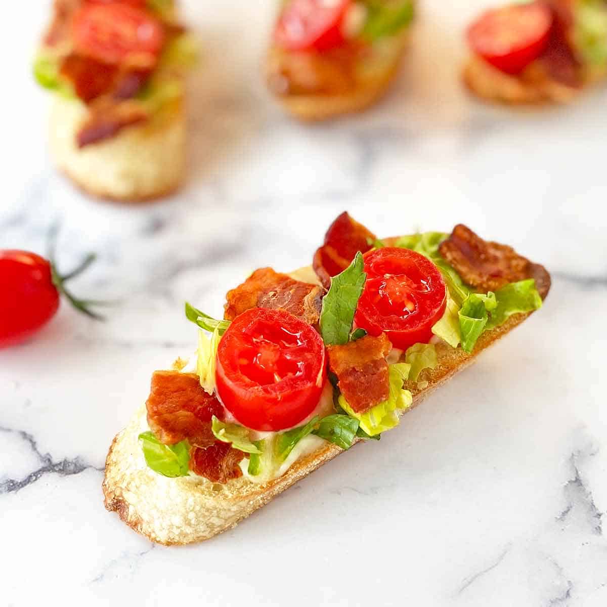 Close up of four bacon lettuce and tomato crostini.