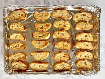 24 lightly toasted crostini on a foil lined baking sheet.